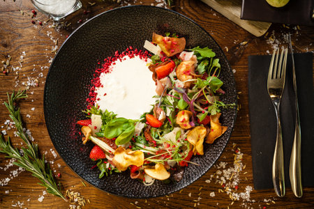 Crudo ham salad. Stracciatella and Grana Padano cheese, sundried tomato, fresh cucumber. Delicious healthy mixed greens food closeup served on a table for lunch in modern cuisine gourmet restaurantの写真素材