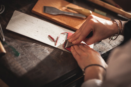 Leather handbag craftsman at work in a vintage workshop. Small business concept.の写真素材