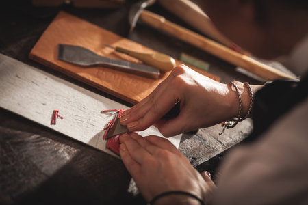 Leather handbag craftsman at work in a vintage workshop. Small business concept.