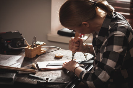 Leather handbag craftsman at work in a vintage workshop. Small business concept.の写真素材