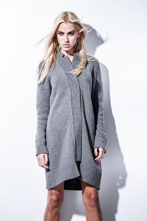 fashion and lingerie concept - beautiful blond lady portrait in grey pullover on white background. Woman wearing underwear poses in bright light.の写真素材