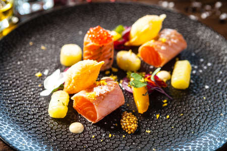 Salted Scottish salmon with trout roe. Marinated cucumber and onion, wonton chips. Delicious healthy Italian traditional food closeup served for lunch in modern gourmet cuisine restaurantの写真素材