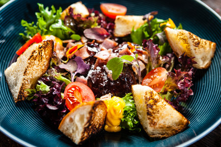Warm chicken liver salad with port wine-honey sauce. Carrot cream, bacon, cherry tomatoes, brioche. Delicious healthy traditional food closeup served for lunch in modern gourmet cuisine restaurantの写真素材