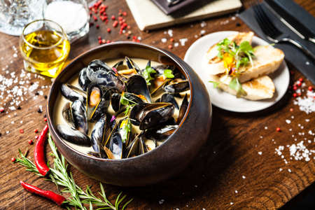 Blue mussels in cream wine sauce. Delicious healthy Italian traditional food closeup served for lunch in modern gourmet cuisine restaurantの写真素材