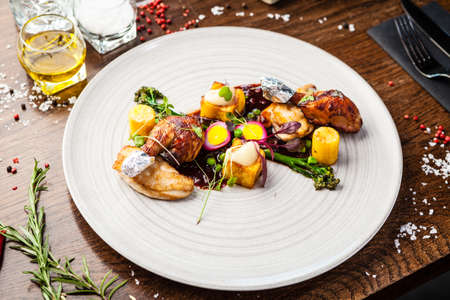 Chicken fillet, Jerusalem artichoke puree, dewberry sauce, potato, quail egg. Delicious healthy traditional food closeup served for lunch in modern gourmet cuisine restaurant.の写真素材