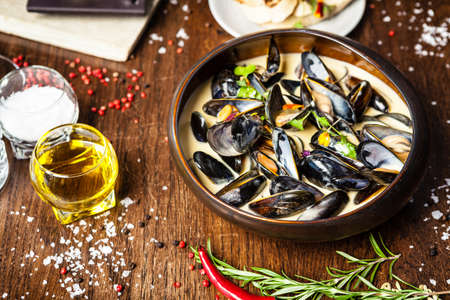 Blue mussels in cream wine sauce. Delicious healthy Italian traditional food closeup served for lunch in modern gourmet cuisine restaurant.の写真素材