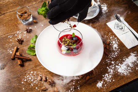Raspberry-pistachio paradise island. Pistachio cream, raspberry panna cotta, almond-pistachio. Delicious healthy traditional food closeup served for lunch in modern gourmet cuisine restaurantの写真素材