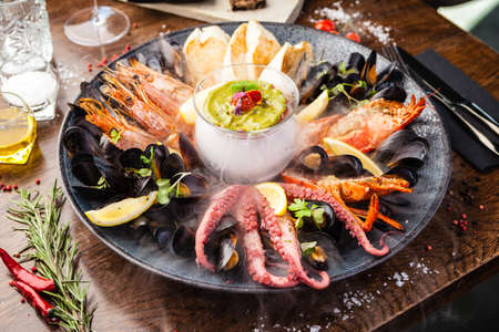 Seafood platter for 2-4 persons. Lobster, octopus, blue mussels, Argentina king prawns, tuna tartare. Delicious healthy traditional food closeup served for lunch in modern gourmet cuisine restaurantの写真素材