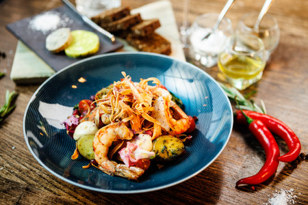 Warm salad with Argentinian king prawns. Almond potato, mini romaine lettuce, carrot, cherry tomato, pesto, black root chips, caramelized walnut, beet balsamic. Food served in modern restaurantの写真素材