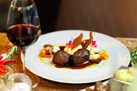 Deer tenderloin. Truffle-potato puree, porcini mushrooms, baked leek and carrot, juniper bread, port wine sauce. Delicious healthy traditional food served for lunch in modern gourmet restaurantの写真素材