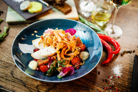 Warm salad with chicken. Almond potato, mini romaine lettuce, carrot, cherry tomato, pesto, black root chips, caramelized walnut, beet balsamic. Food closeup served for lunch in modern restaurantの写真素材
