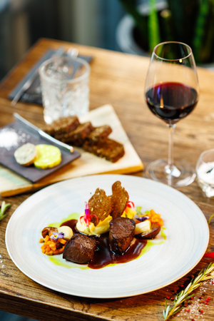 Deer tenderloin. Truffle-potato puree, porcini mushrooms, baked leek and carrot, juniper bread, port wine sauce. Delicious healthy traditional food served for lunch in modern gourmet restaurantの写真素材