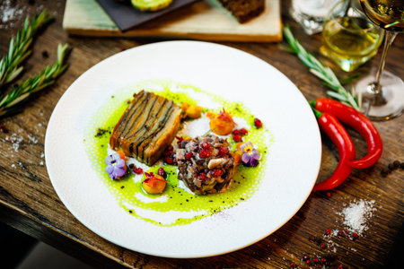 Shiitake and potatoes. Vegan. Shiitake mushroom, potato gratin, Beluga lentils, yellow beet cream. Delicious healthy traditional food closeup served for lunch in modern gourmet cuisine restaurantの写真素材