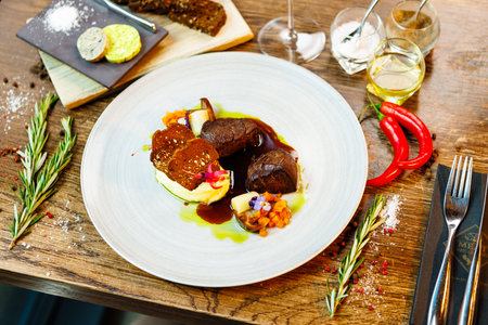 Deer tenderloin. Truffle-potato puree, porcini mushrooms, baked leek and carrot, juniper bread, port wine sauce. Delicious healthy traditional food served for lunch in modern gourmet restaurantの写真素材