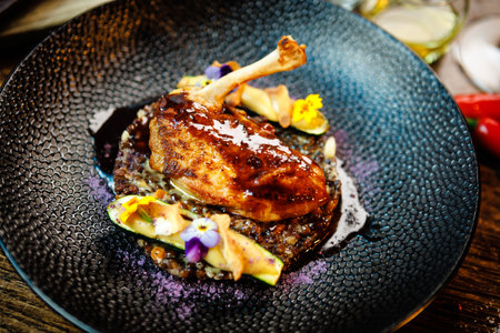 Corn chicken supreme. Beluga lentils, Old Ammerlander cheese, mini zucchini, red wine sauce. Delicious healthy traditional food closeup served for lunch in modern gourmet cuisine restaurantの写真素材