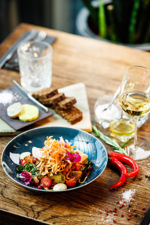 Warm salad with chicken. Almond potato, mini romaine lettuce, carrot, cherry tomato, pesto, black root chips, caramelized walnut, beet balsamic. Food closeup served for lunch in modern restaurantの写真素材