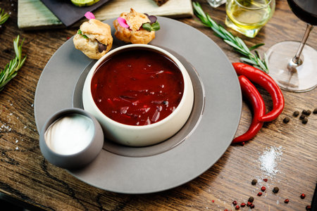Beetroot soup Borscht with meat and sourcream in a bowl. Delicious healthy Ukrainian traditional food closeup served for lunch on a table in modern gourmet cuisine restaurantの写真素材