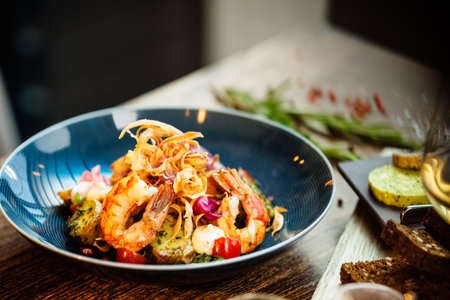 Warm salad with Argentinian king prawns. Almond potato, mini romaine lettuce, carrot, cherry tomato, pesto, black root chips, caramelized walnut, beet balsamic. Food served in modern restaurantの写真素材