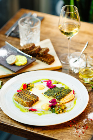 Pike-perch fillet. Potato gratin, warm yellow beet-turkey bean salad, parmesan dressing. Delicious seafood fish closeup served on a table for lunch in modern cuisine gourmet restaurantの写真素材