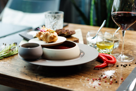 Beetroot soup Borscht with meat and sourcream in a bowl. Delicious healthy Ukrainian traditional food closeup served for lunch on a table in modern gourmet cuisine restaurantの写真素材