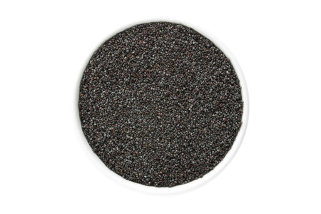 Poppy seeds in a cup from above isolated on white backgroundの写真素材