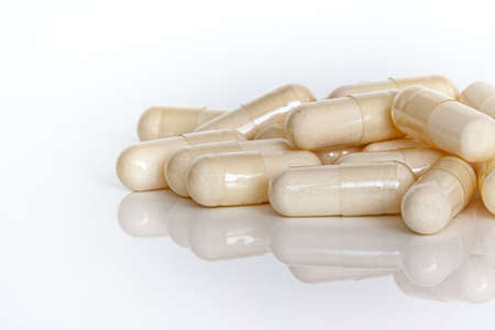 A pile of vitamin capsules detail isolated on a white background.の写真素材