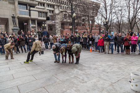 Boston, MA, USA - March 1, 2014: People in winter clothes are watching the street performance at Freedom Trail near the Boston City Hallのeditorial素材