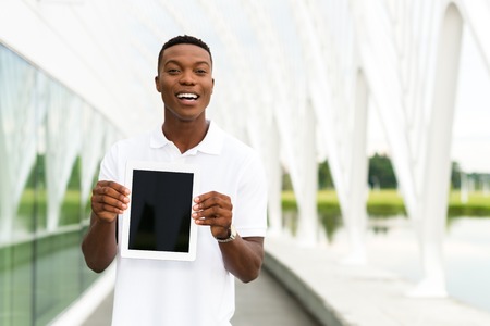 Black, African American college student showing a digital tablet computerの写真素材