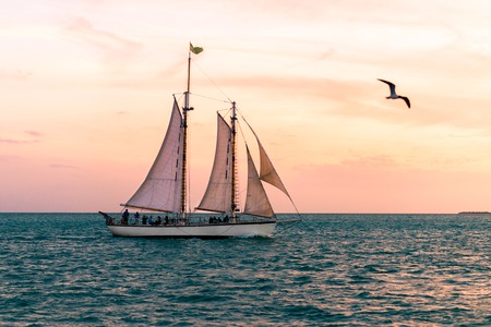 Tourists watch the sunset from a schooner off of Key Westの写真素材