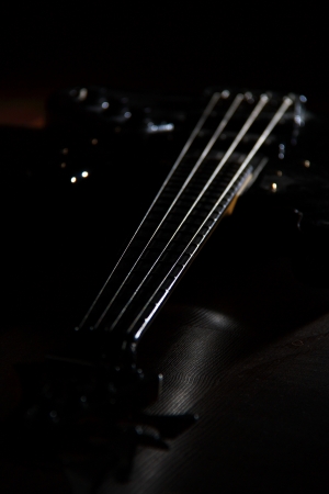 bass guitar with four strings on black ground の写真素材