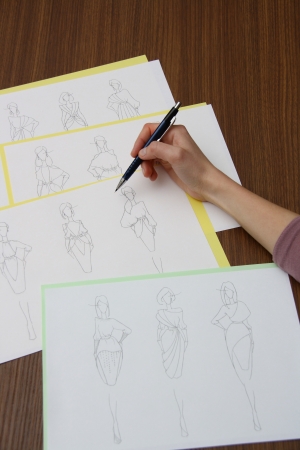 designer assessing fashion drawings on the collection of clothesの写真素材