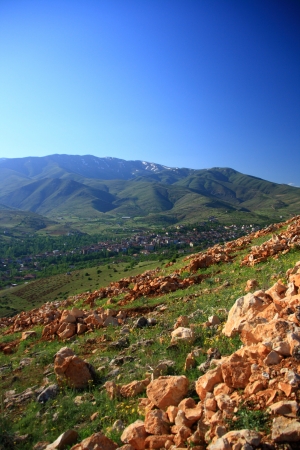 village between hills on spring day with blue skyの写真素材