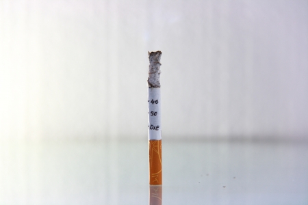 cigarette burning in front of white backgroundの写真素材