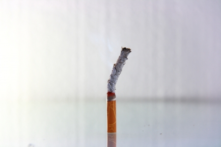 cigarette burning in front of white backgroundの写真素材