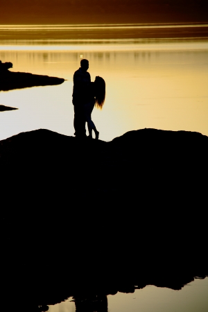 romantic couple dancing near lake at sunset timeの写真素材