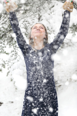 Happy woman in winter with snow looking blissfulの写真素材