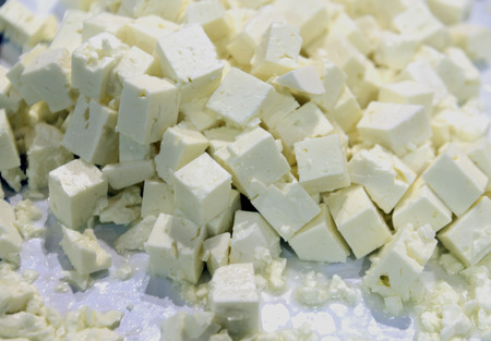 many square greek feta pieces on a trayの写真素材