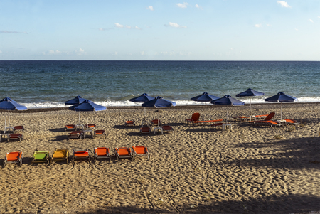 view Cretan beach in summer with umbrellas and sun bedsの写真素材