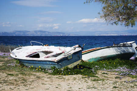 morning summer greek sea with old boats near the shoreの写真素材