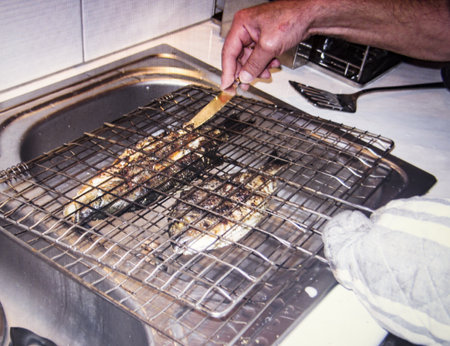 fried sea dorada in a metal mesh for grillingの写真素材