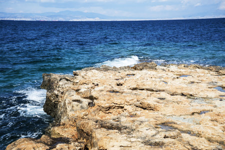 Rocky coastline of Aegina island in summer. Blue sky with intense white clouds. Greeceの写真素材