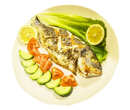 Dorado fish fried with vegetables in porcelain plate isolated on white backgroundの写真素材