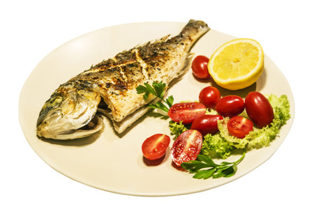 grilled dorado fish with fresh vegetables on white backgroundの写真素材