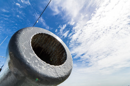 antique battle ship cannon with blue sky.