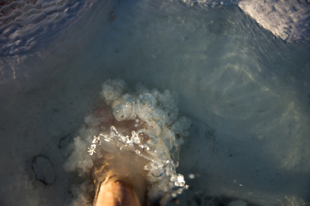 man churning water by foot in the small waterpool with thermal water in Pamukkaleの写真素材