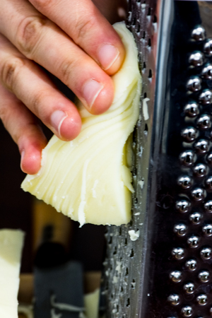 woman shredding the piece of the  cheeseの写真素材