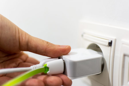 Girl putting phone charger with two connected cable into the socket