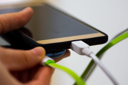 Two mobile phones charging pluged into the charger