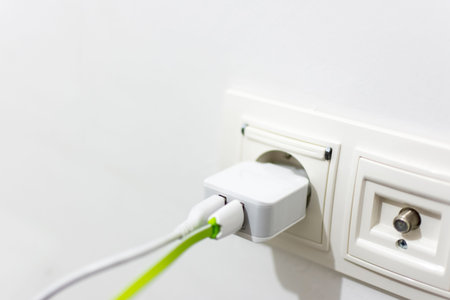 Phone charger with two connected cables pluged into the outlet