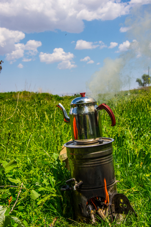 While family enjoying their time in nature they put the turkish tea on the fire to be ready for drinkingの写真素材
